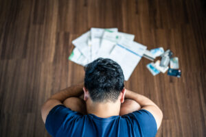Man struggling with the weight of overwhelming financial stress